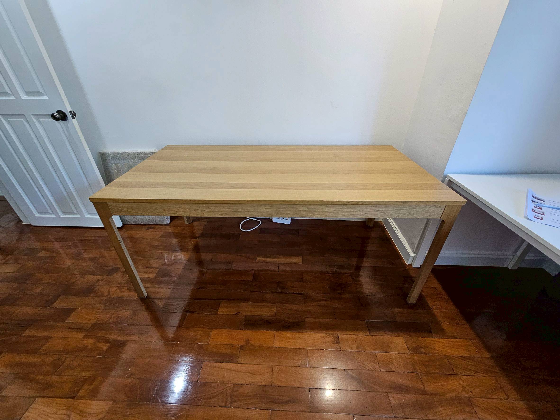 Wooden dining table, matte oak veneer, light wood color, IKEA brand.
