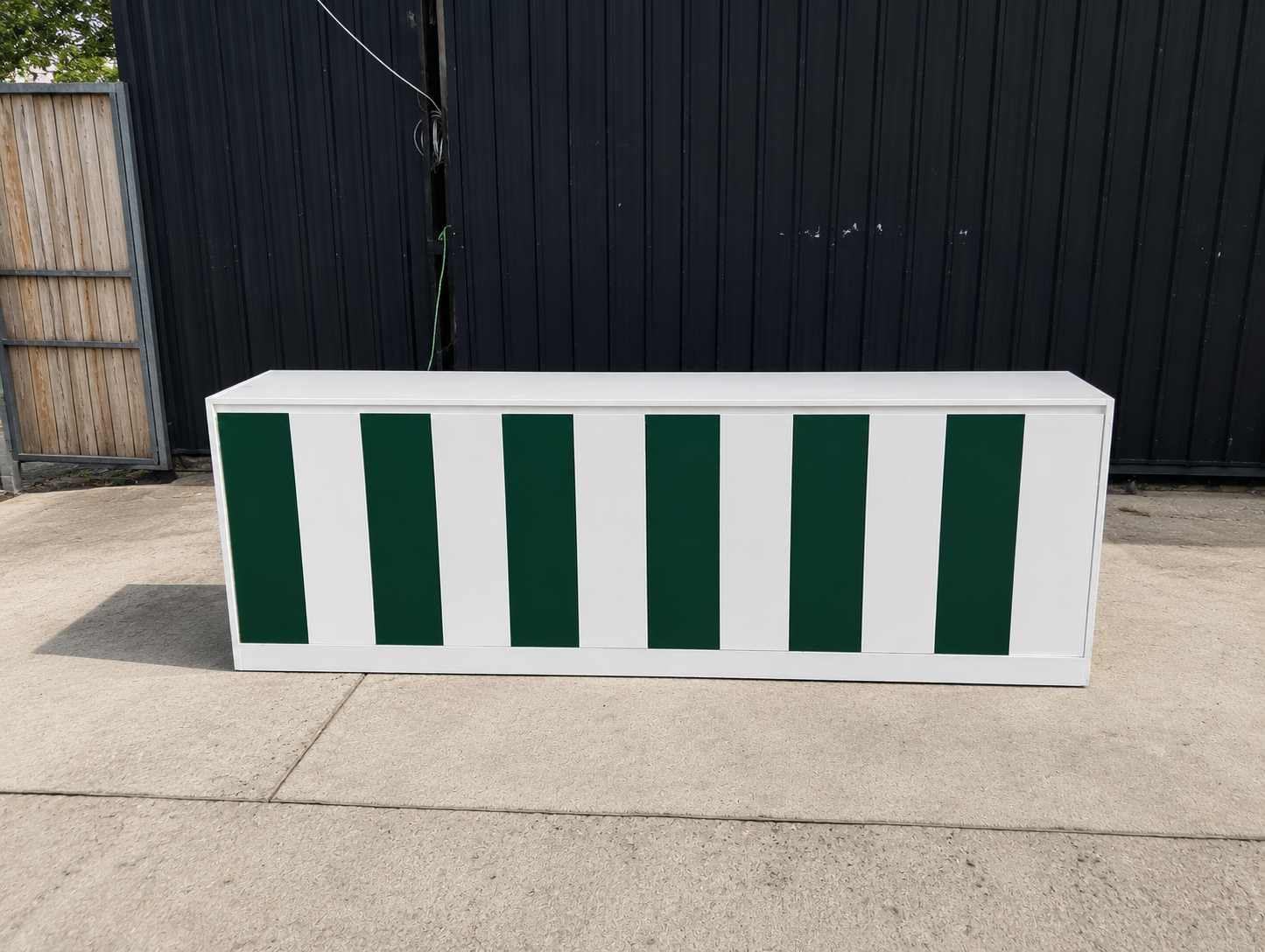 Multipurpose wooden storage cabinet with 6 compartments, white with green stripes.