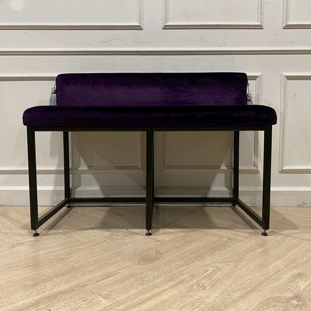 Two-seater chair with steel legs and purple velvet upholstery.