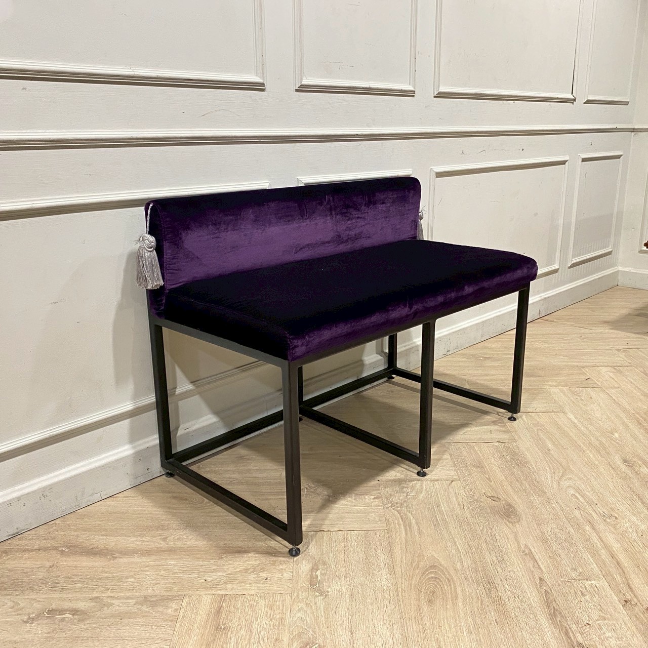Two-seater chair with steel legs and purple velvet upholstery.