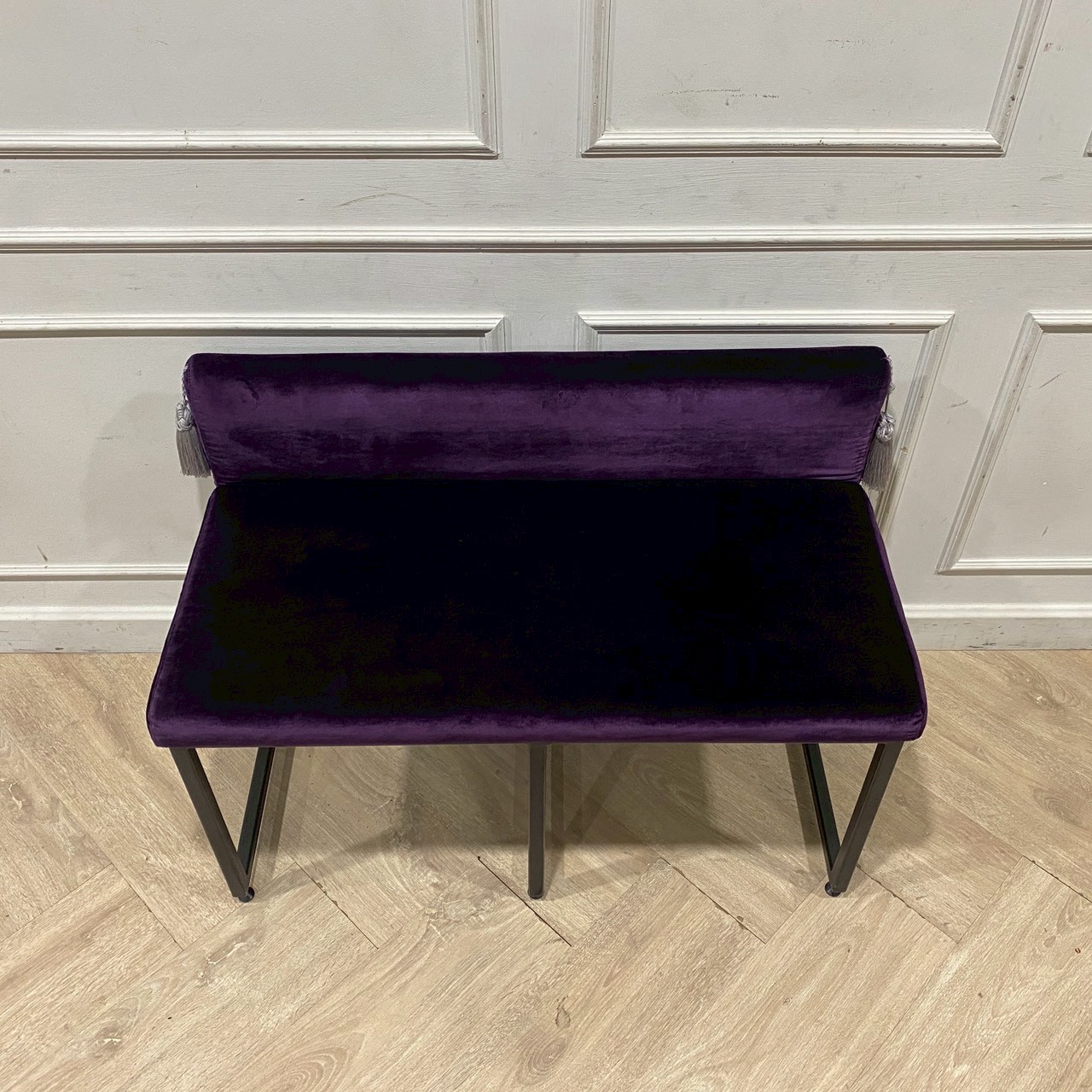Two-seater chair with steel legs and purple velvet upholstery.