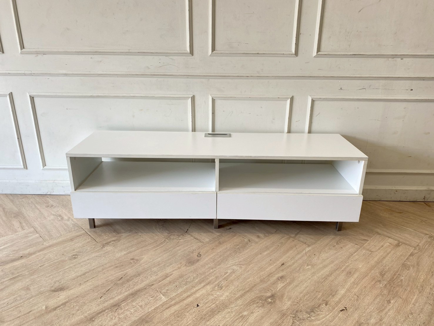 白色木质电视柜，带两个抽屉和两个储物格，含电源插座。