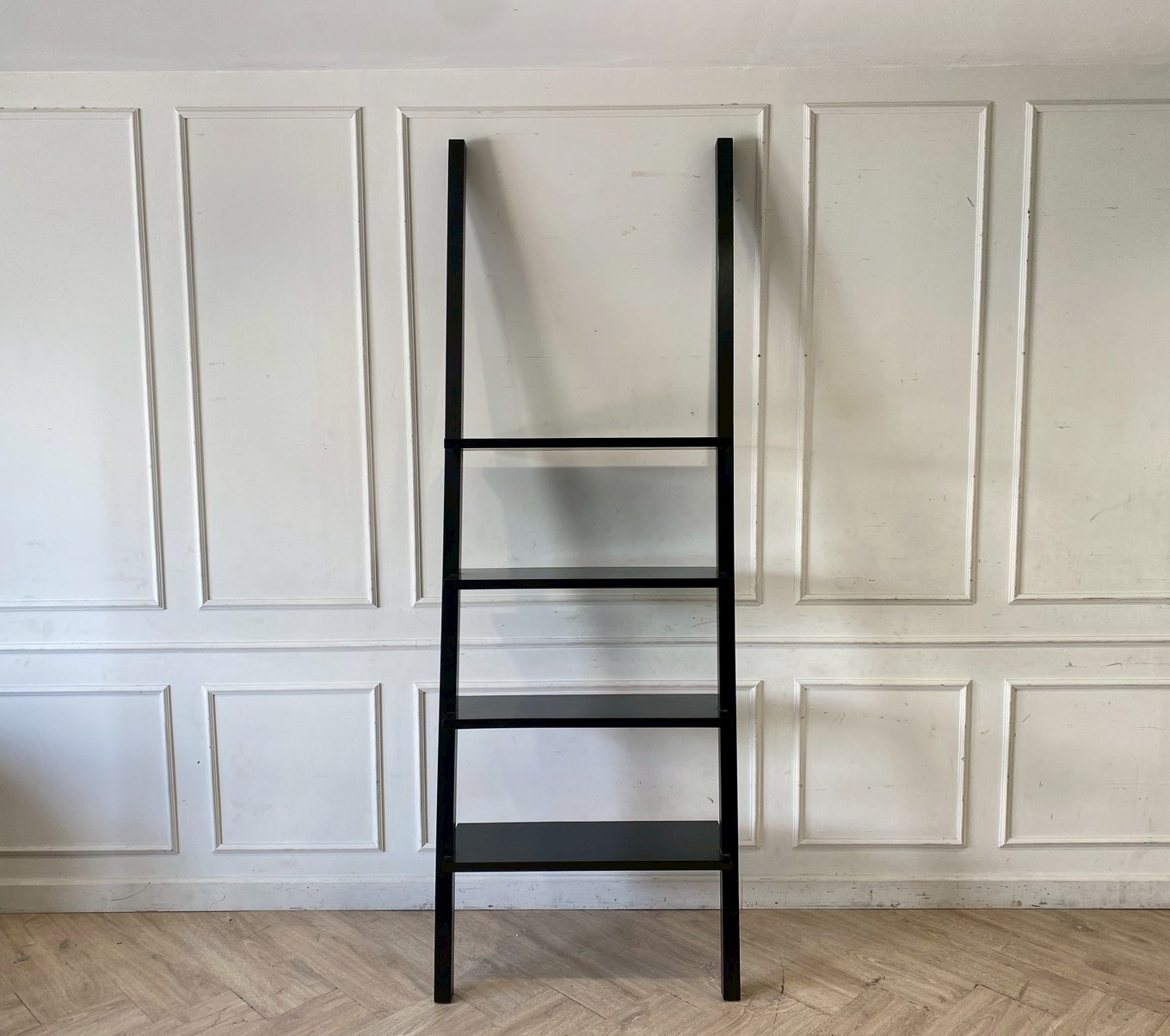 Black wooden ladder-shaped shelving unit