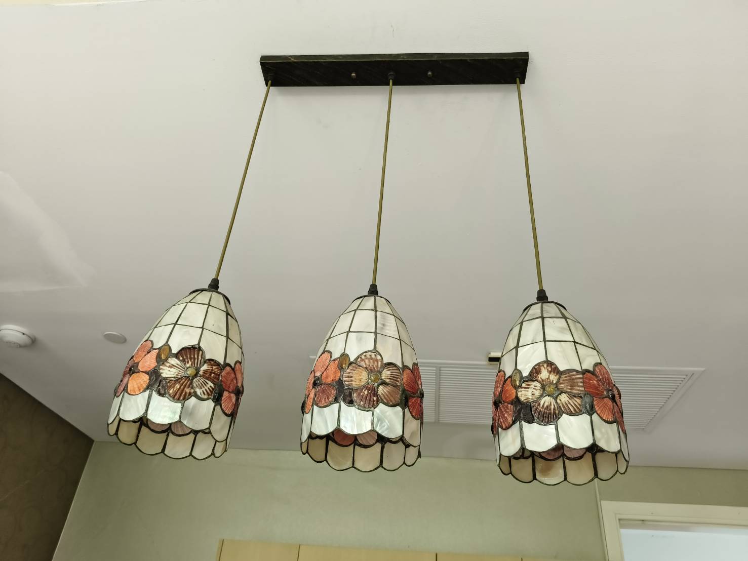 Three pendant ceiling lights with a floral design.