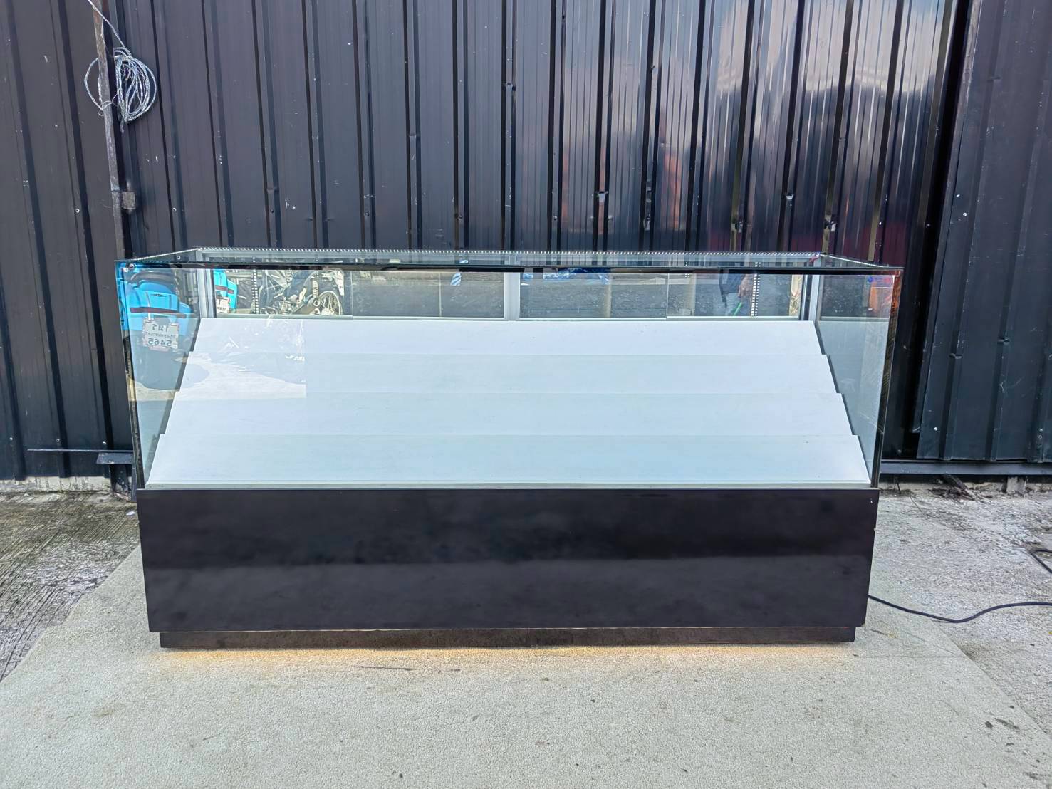 Glass Retail Display Counter with White Tiered Shelves, LED Lighting, and a Glossy Black Base