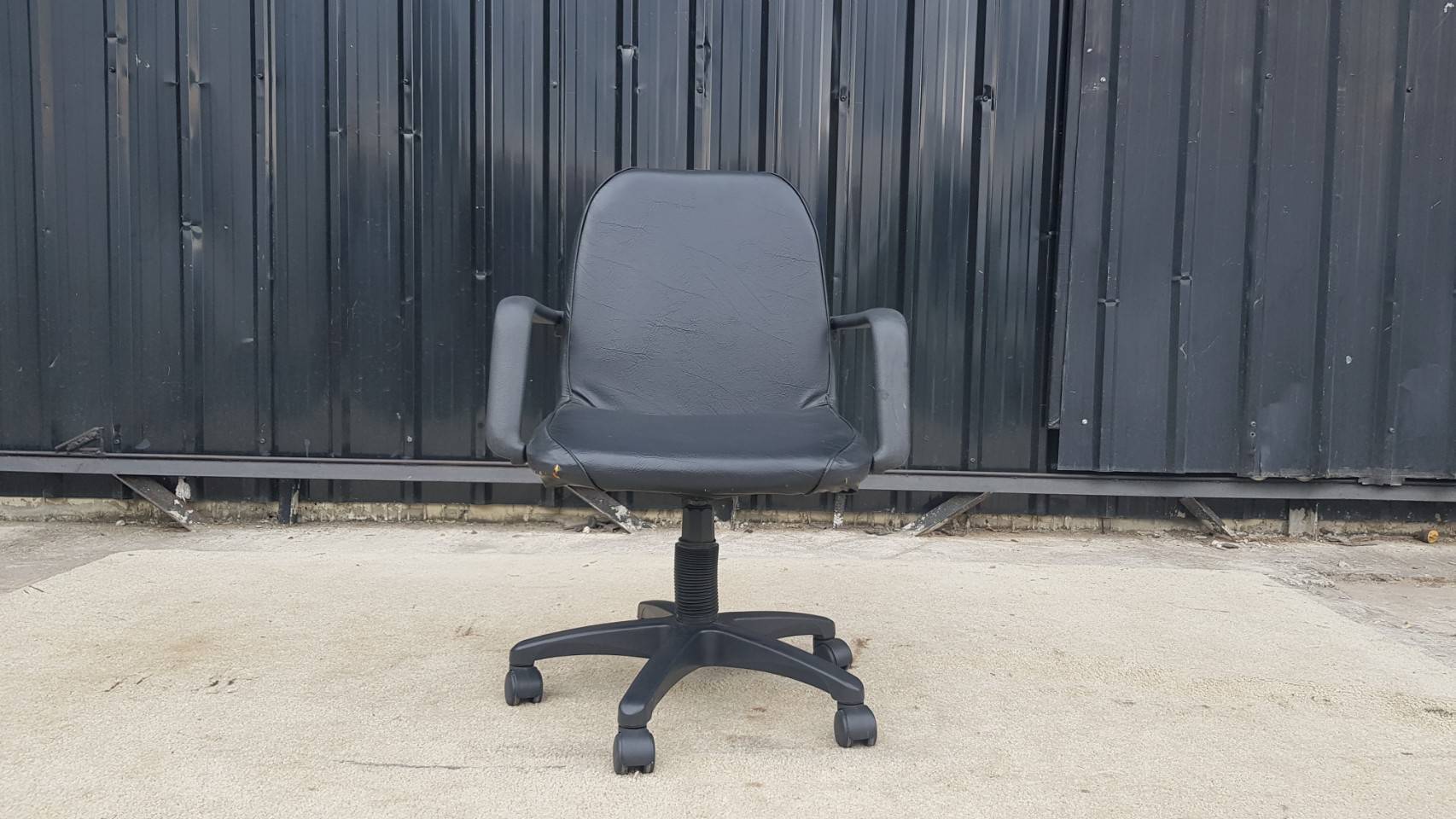 黑色办公椅，带轮，真皮靠背和座椅。