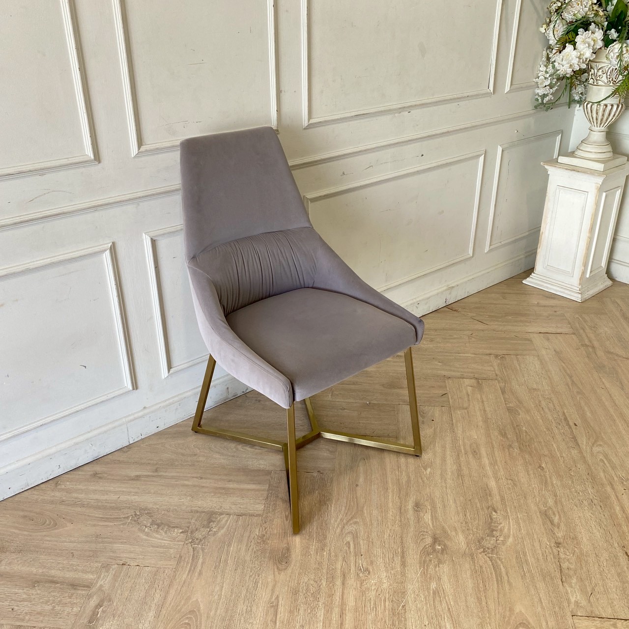 椅子配有金色金属椅腿和灰色天鹅绒椅面。