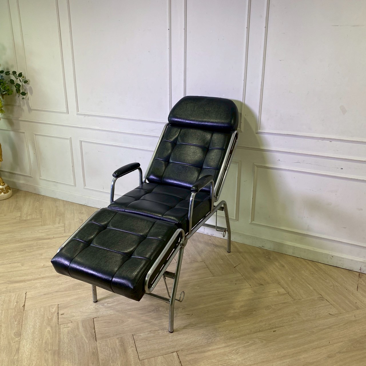 面部按摩床，钢制床腿，黑色皮革软垫。
