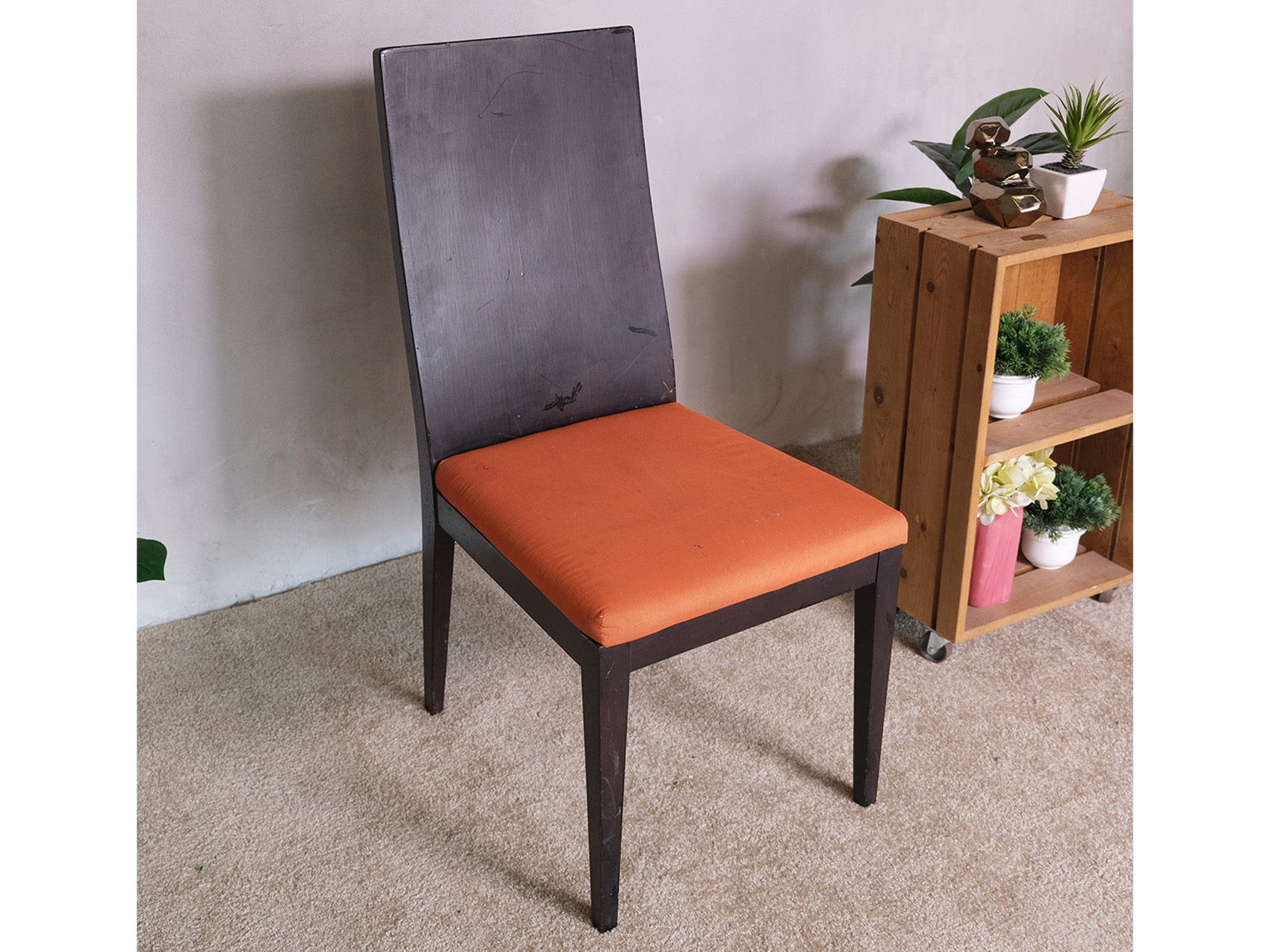 Wooden chair, orange fabric cushion, beautiful frame, slightly curved backrest.