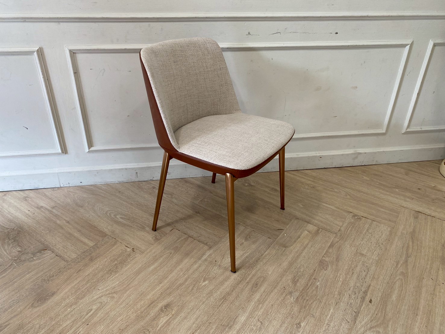 Chair with gray fabric cushion and gold legs